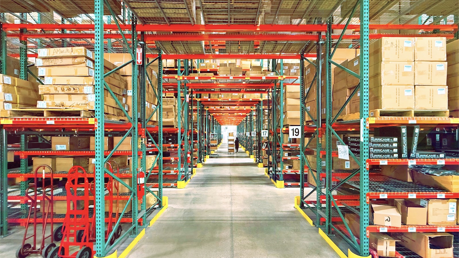 Pasillo de depósito con estanterías llenas de productos y cajas